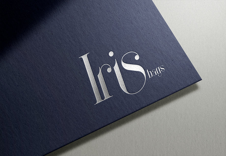 IRIS Bags Embossed Logo – Elegant branding showcased on textured blue paper, highlighting premium craftsmanship.