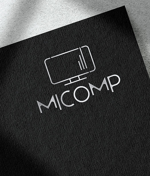 MiComp Logo – Striking brand identity embossed on black textured paper, emphasizing strength and sophistication.
